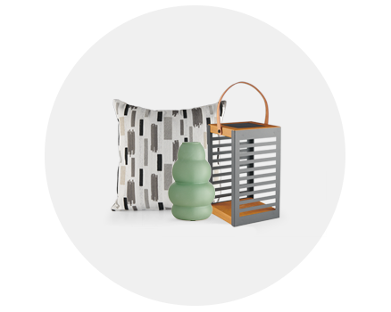 Decorative pillow, green vase, and a lantern on a white background.