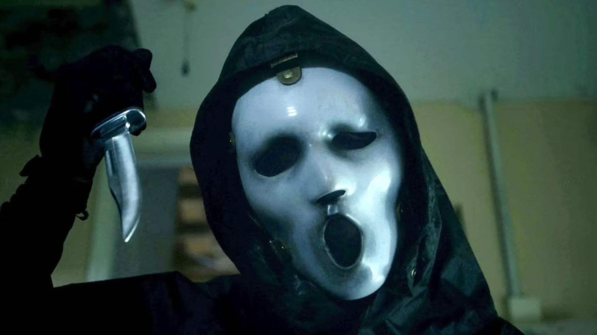 Person in a mask holding a knife, appearing menacing.