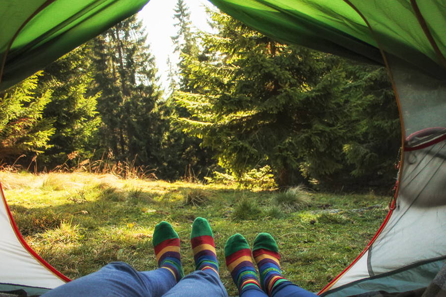 2 pairs of feet in matching socks in tent opening