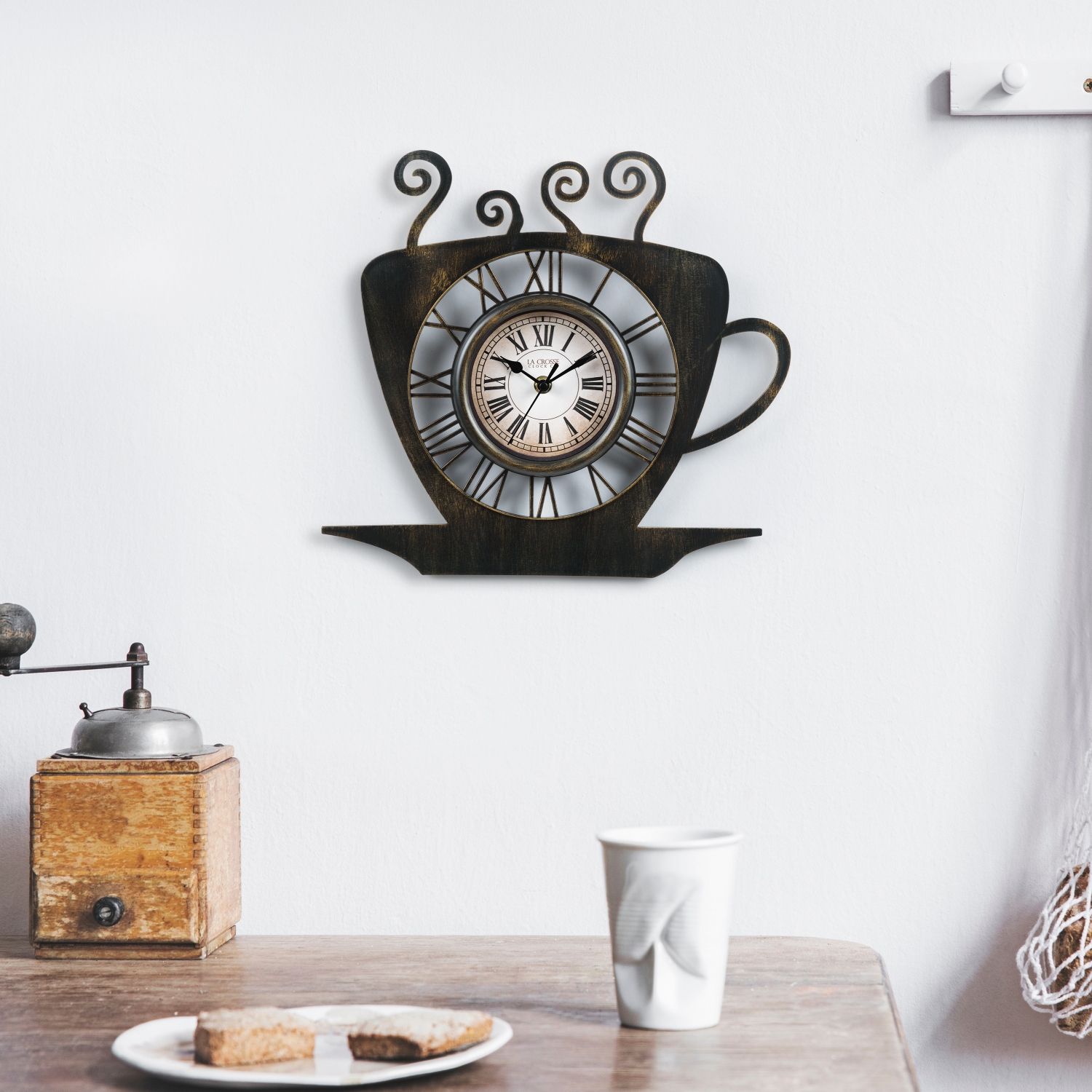 13-inch Latte Wall Clock designed as a coffee cup with a saucer, placed above a table.