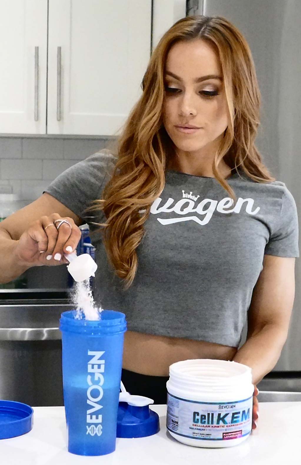 Athlete scooping Cell KEM into a shaker in the kitchen