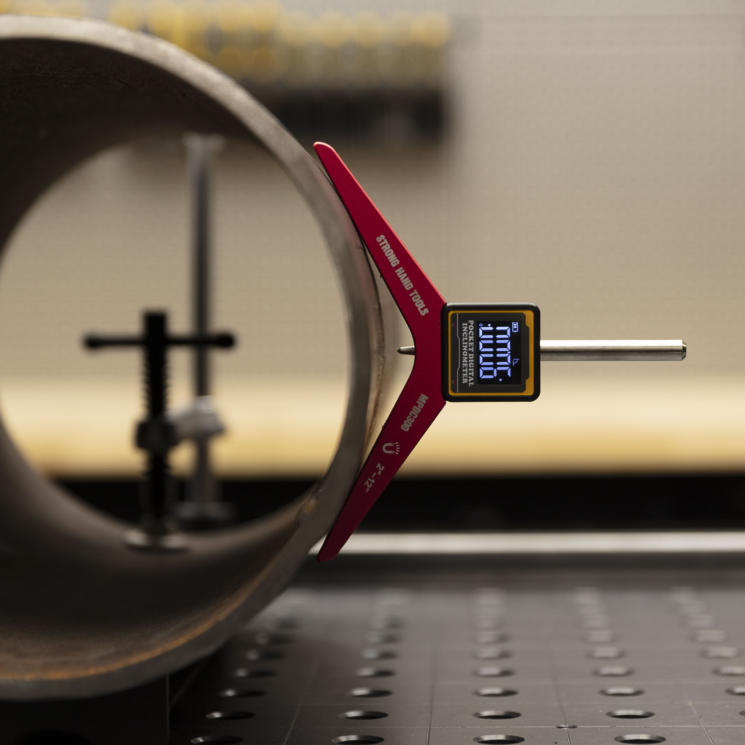 Caliper measuring the diameter of a cylindrical object in a workshop setting.