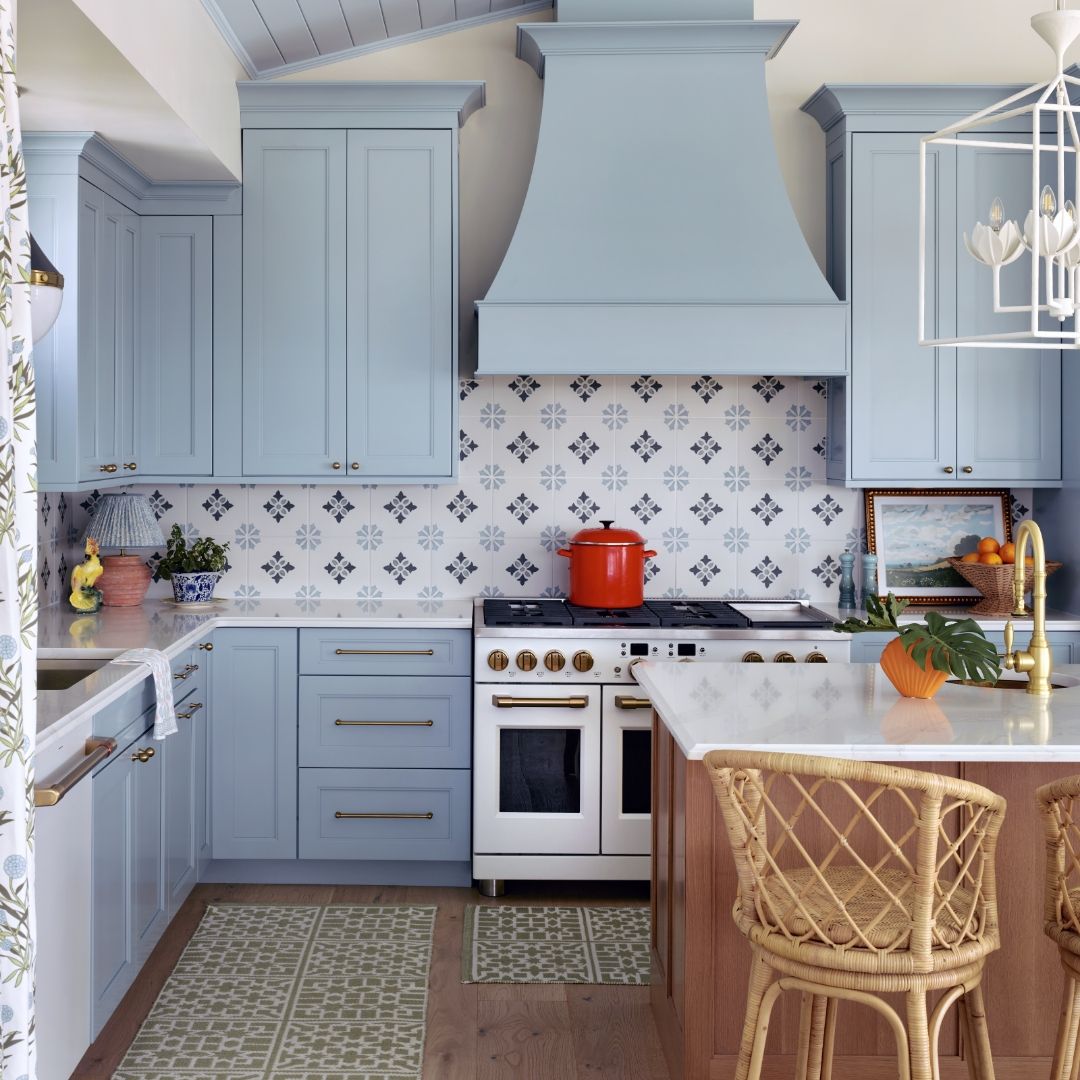 Kitchen in Gasparilla, FL with blue cabinets, CAFE matte white appliances, and patterned backsplash.