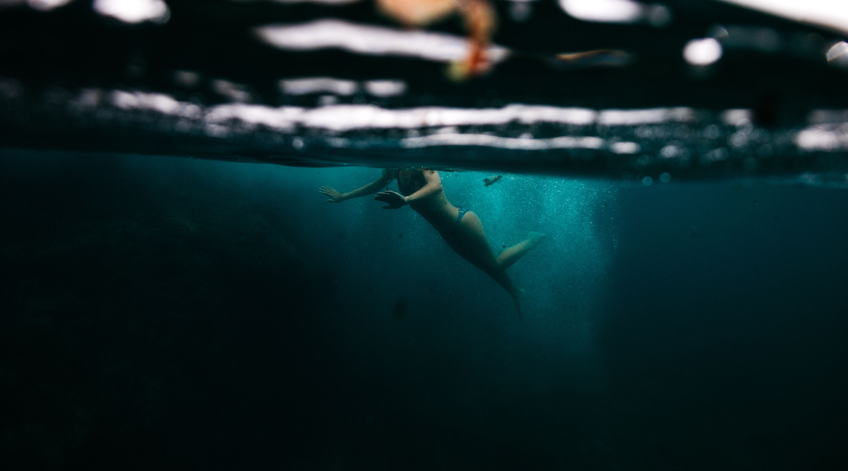 A fish swimming beneath the water's surface with light above.