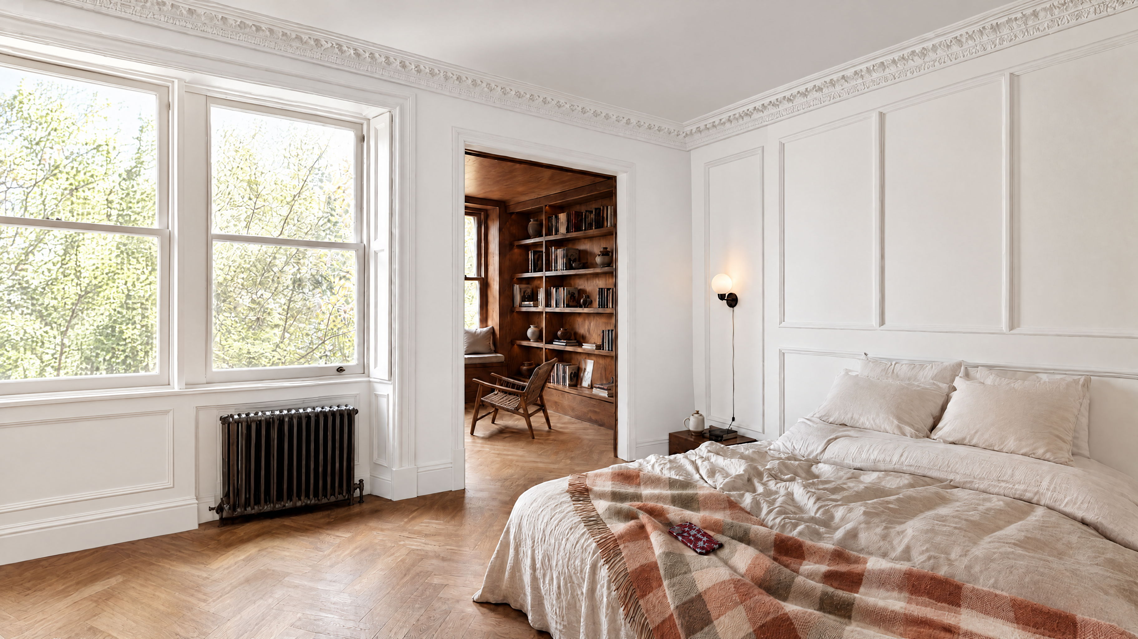 Bedroom images of a bed with a tarten blanket on the right, white walls and herringbone floor
