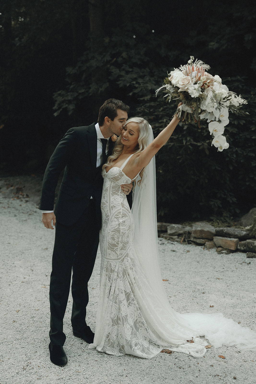 Le marié et la mariée tenant un bouquet