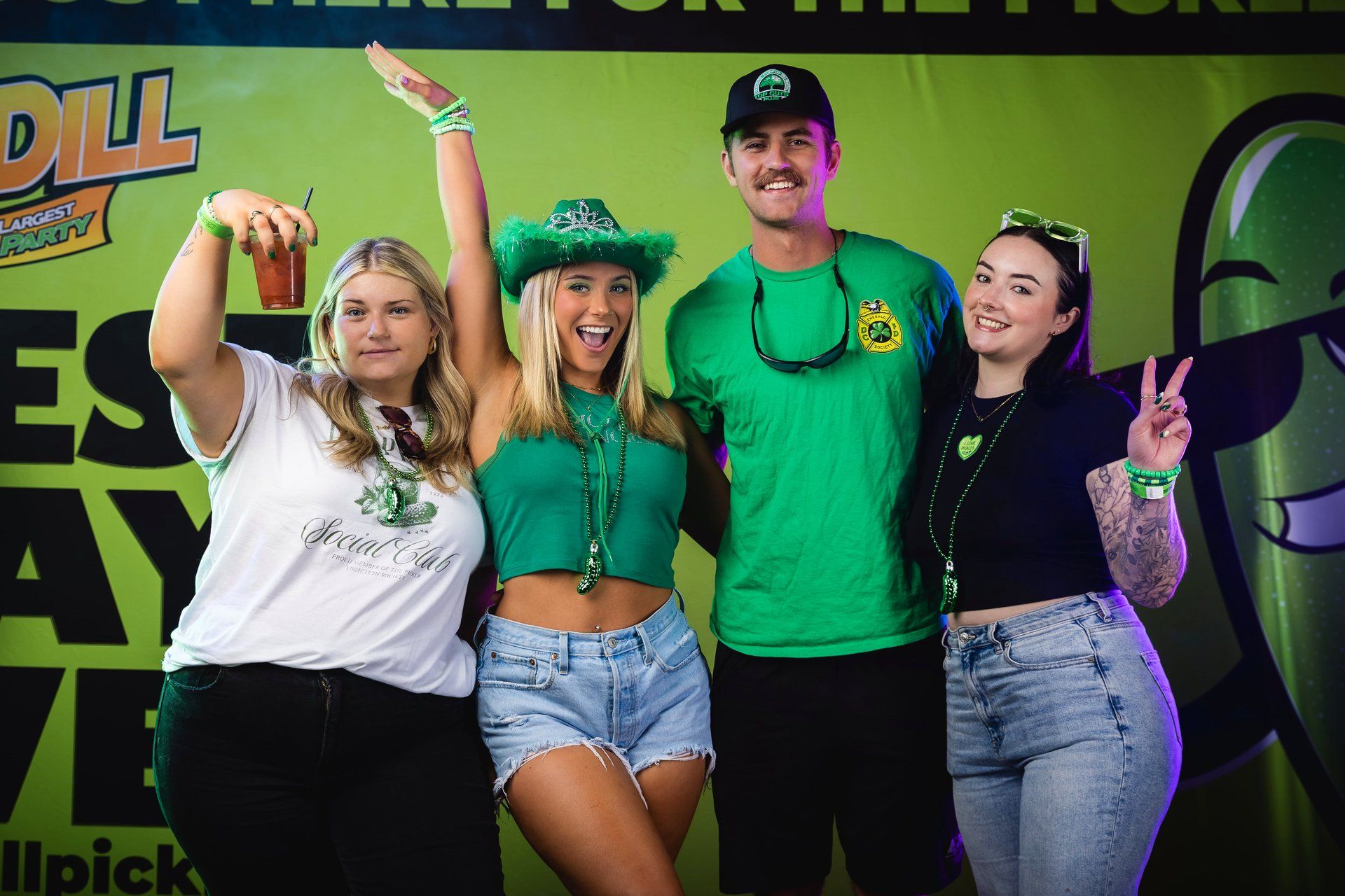 Four friends pose in front of the Best Day Ever, World's Largest Pickle Party activation wall at The Big Dill pickle festival, Power Plant Live!, Baltimore Maryland 2025