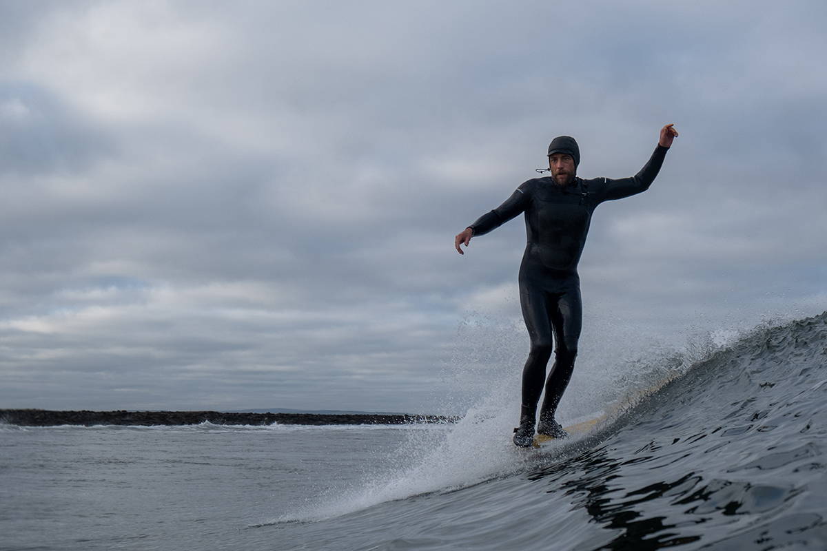 Finisterre Ambassador Mike Lay Poised on the nose of his longboard