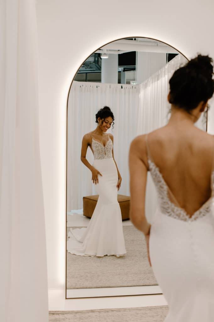 La mariée se regarde dans un miroir en arc et porte la robe Lena de Grace Loves Lace.