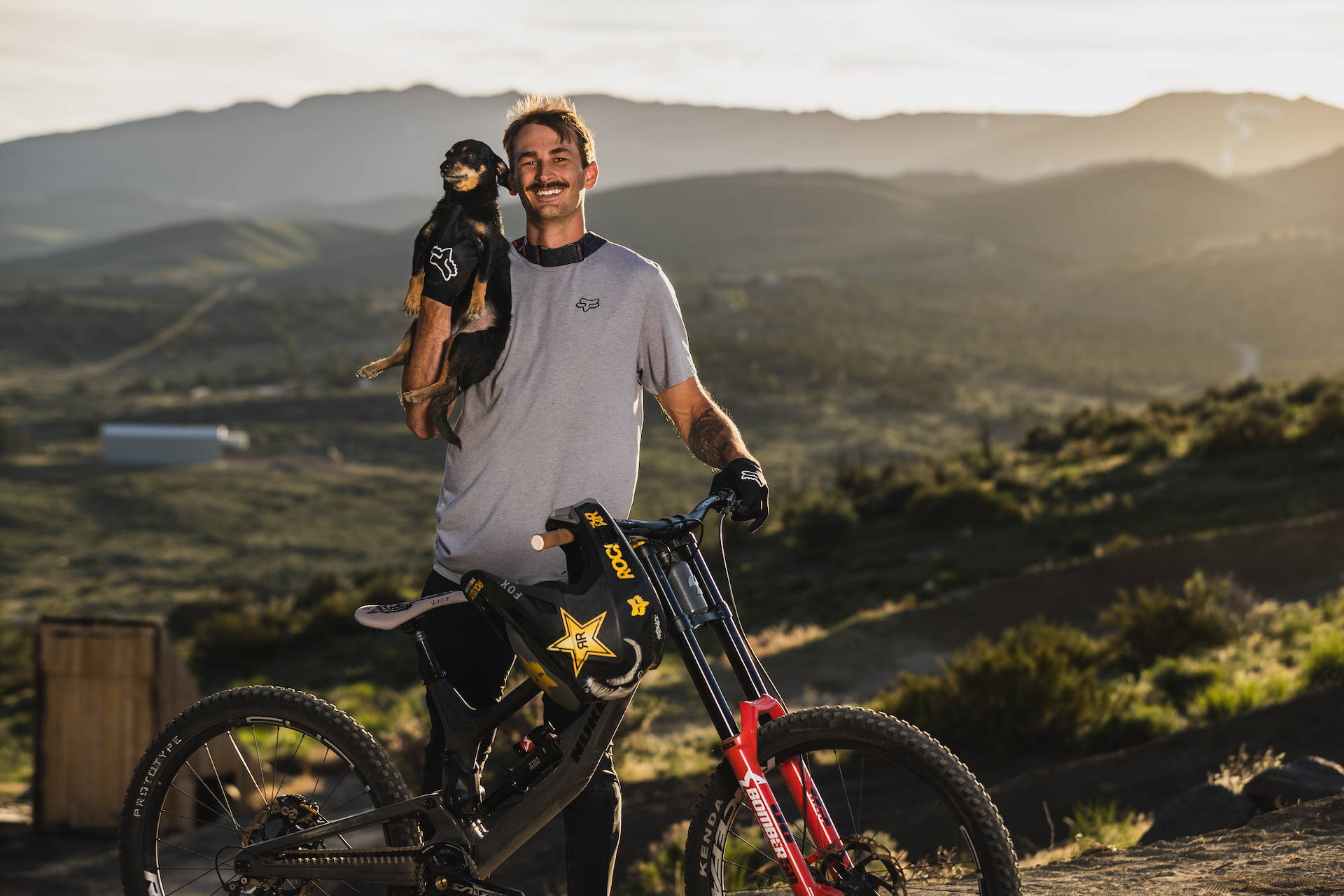 DJ Brandt and doggo with his Nukeproof Dissent downhill bike