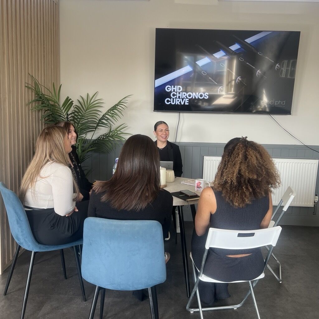 Group of people seated at a table completing a Ghd training workshop.