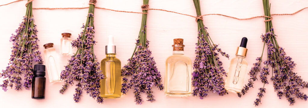 Bottles of essential oils with lavender hanging on a string.