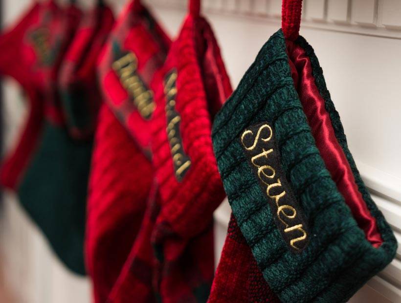 Red and green Christmas stockings hanging with men's names on them