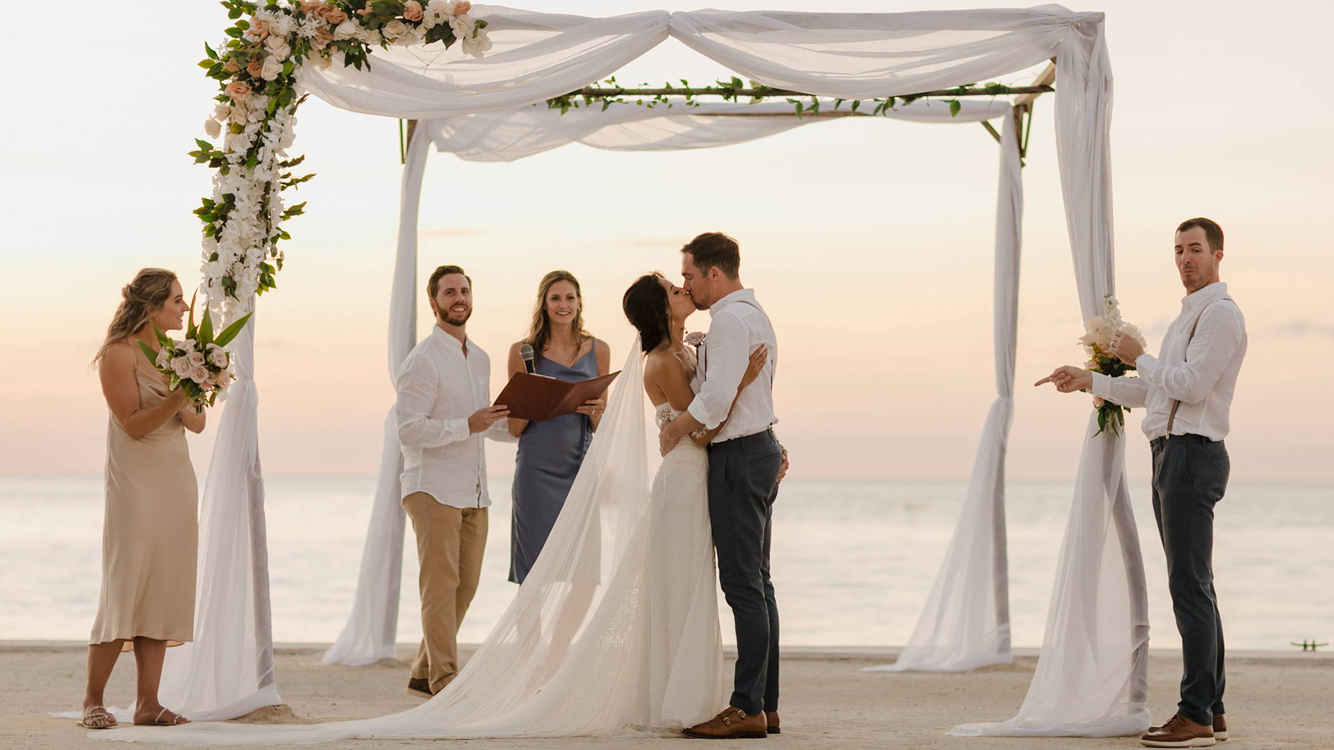 Grace Loves Lace bride wearing the Noah wedding dress kissing her new husband at the wedding ceremony 