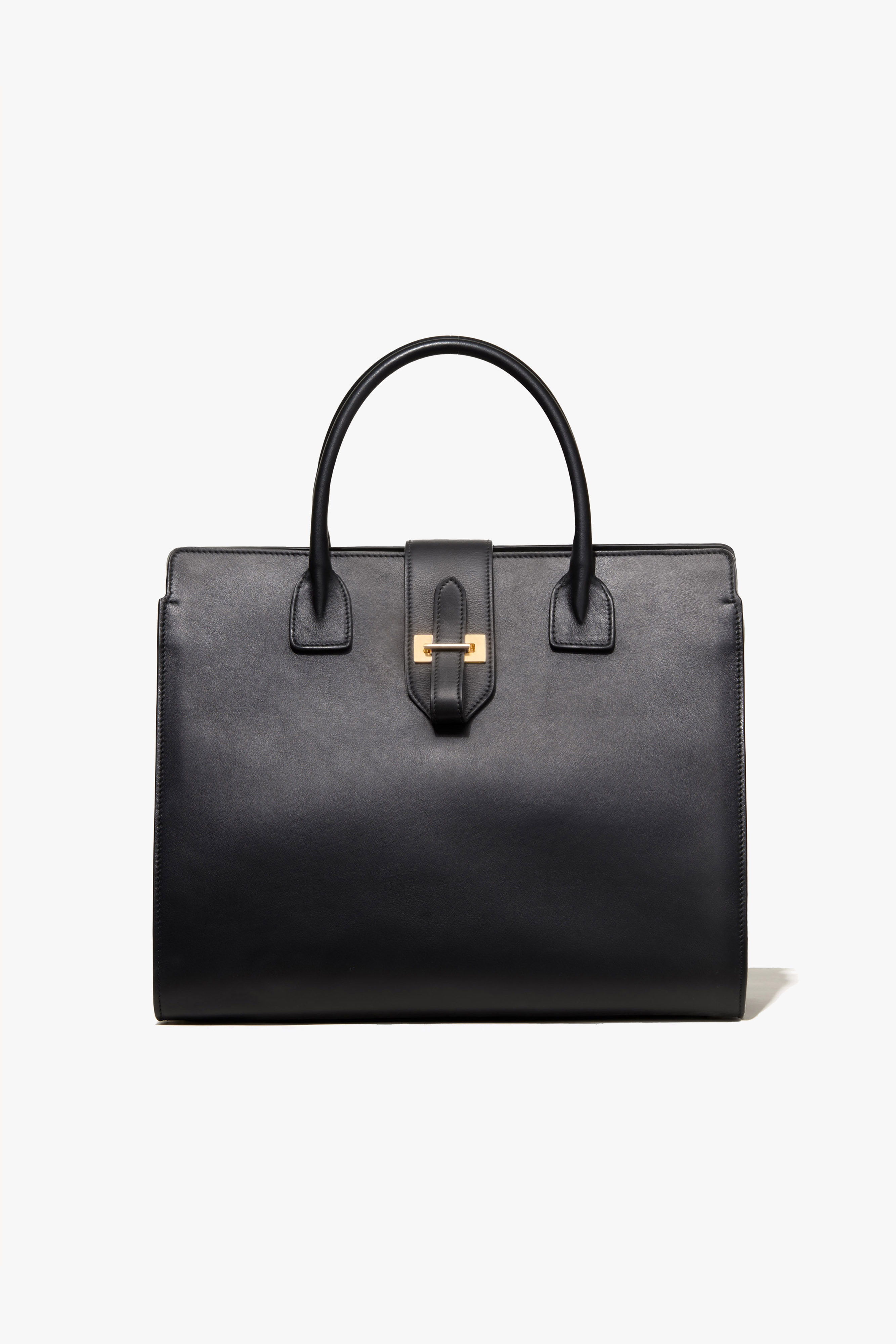 Black leather handbag with top handles and a gold clasp.