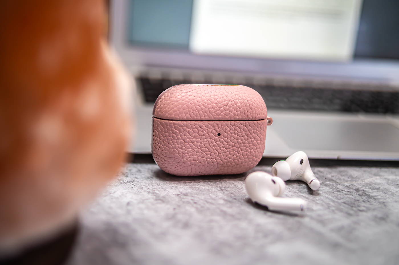 pink genuine leather airpods pro case standing up on a granite table