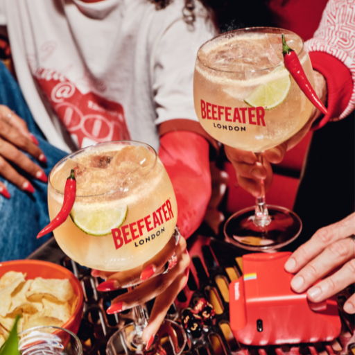 Two cocktails with lime and chili, branded Beefeater, on a colorful table.