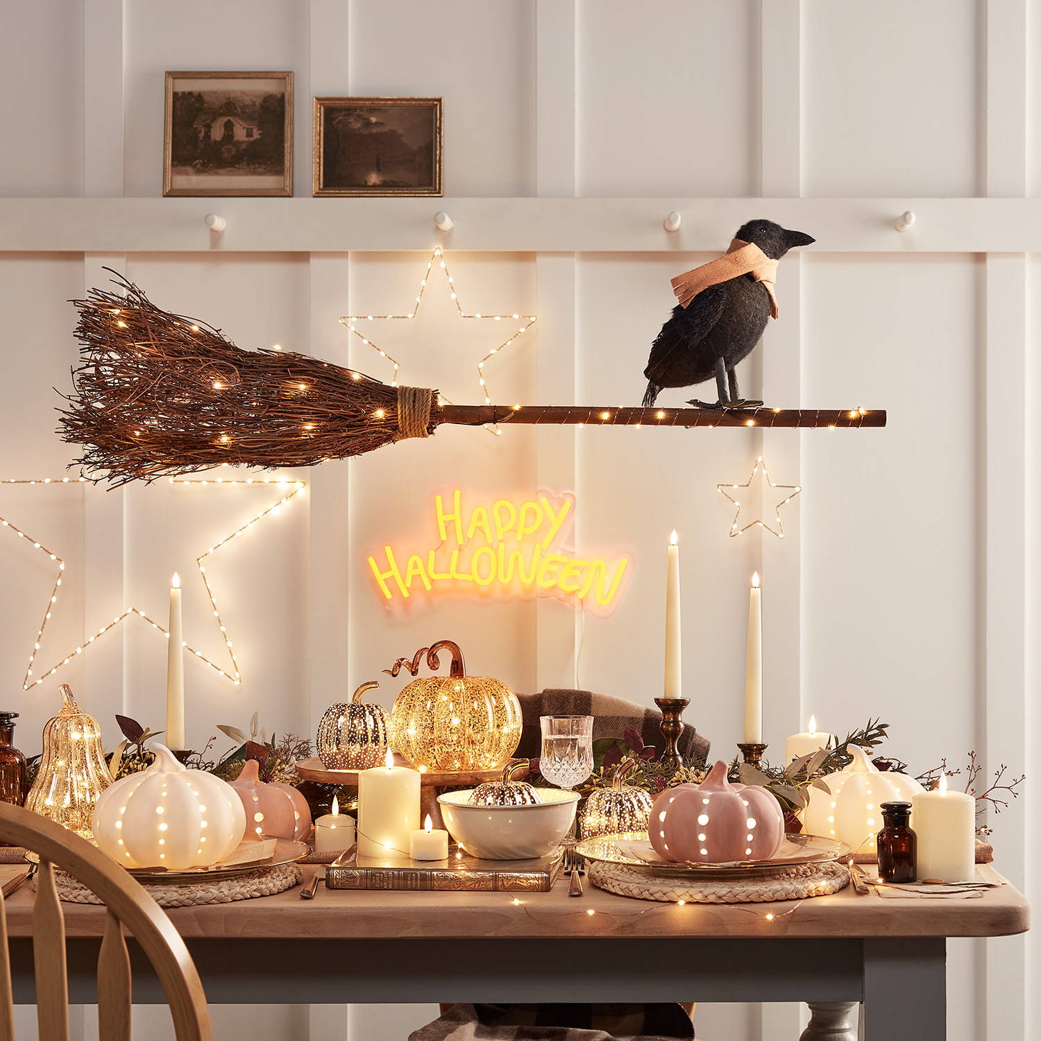 Déco de table d'halloween  composée de citrouilles lumineuses, de balai de sorcière, de crawford le corbeau. 