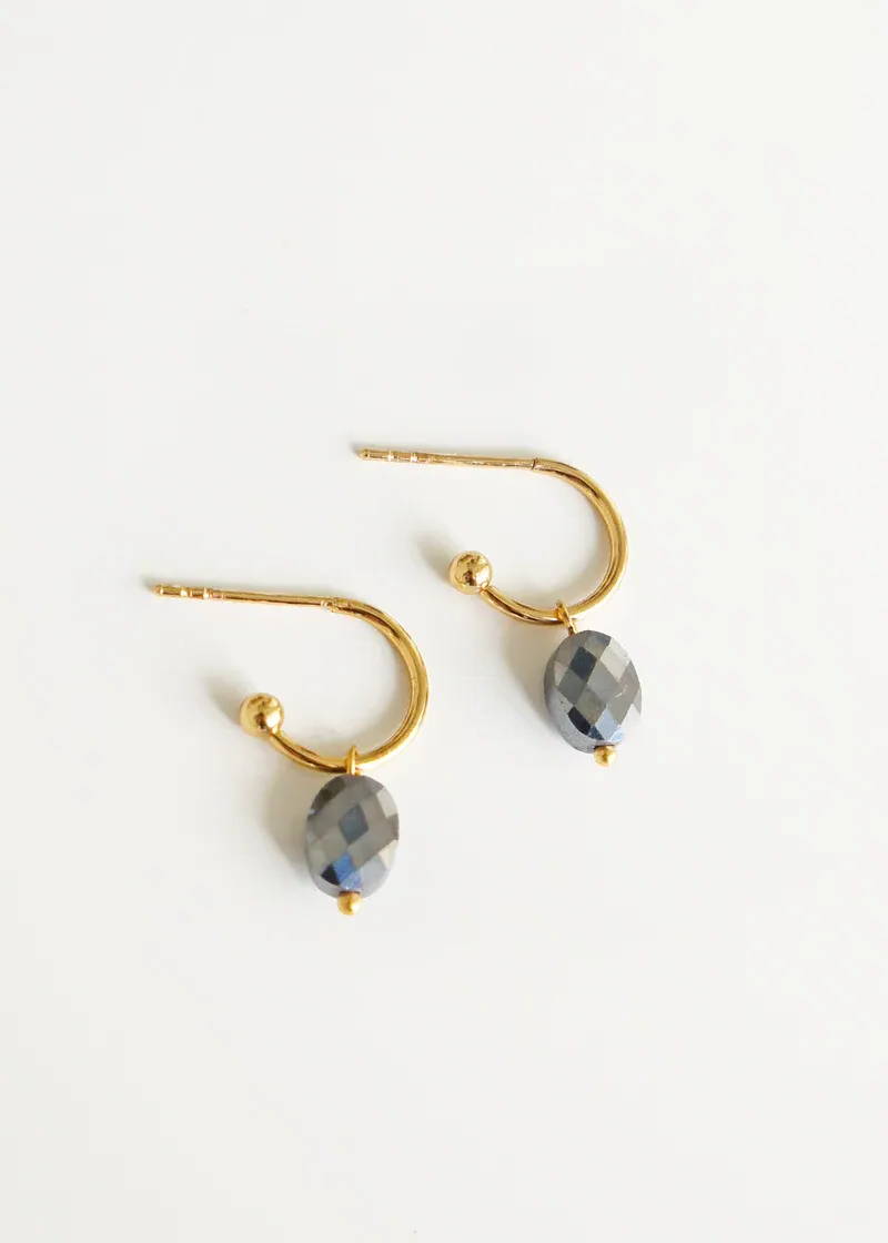 A pair of gold drop, dangly earrings with smokey grey faceted pendants