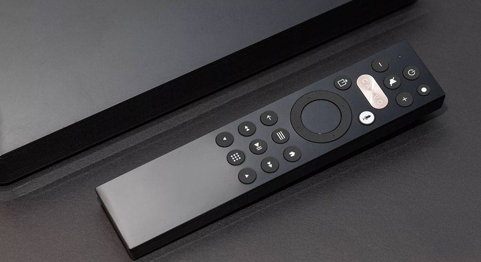 The Caavo remote on top of a black surface