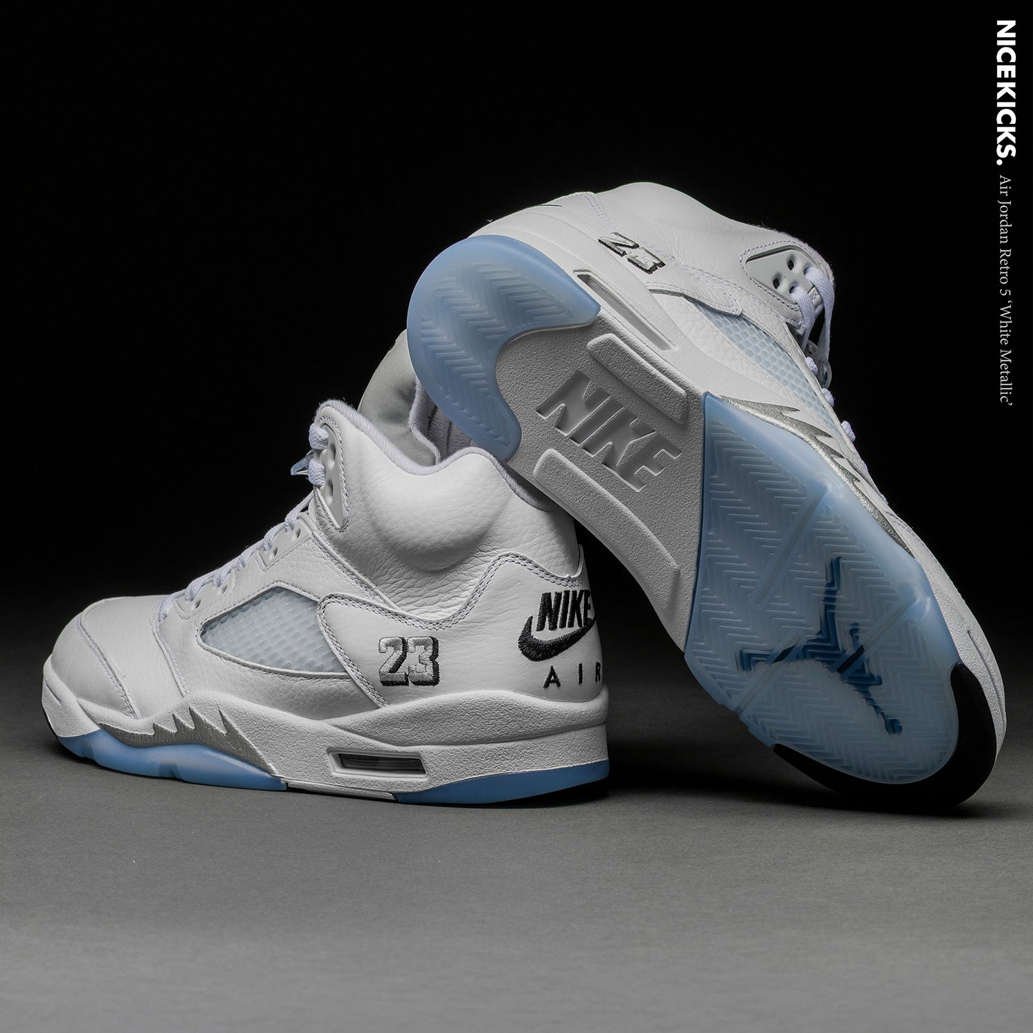 White Air Jordan 5 sneakers with icy blue soles displayed on a dark background.