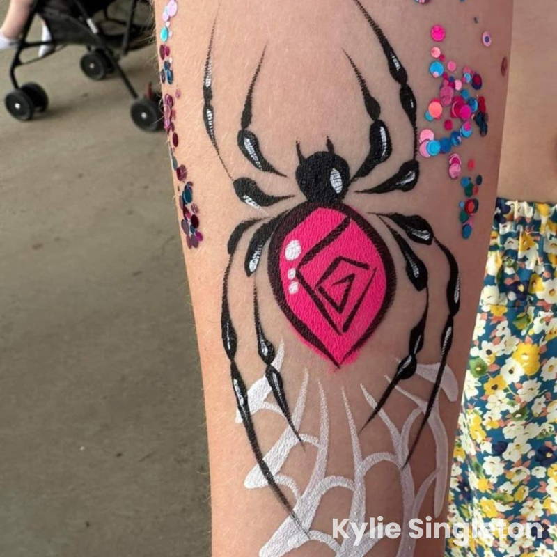 spider face paint on arm, pink body, spiderweb