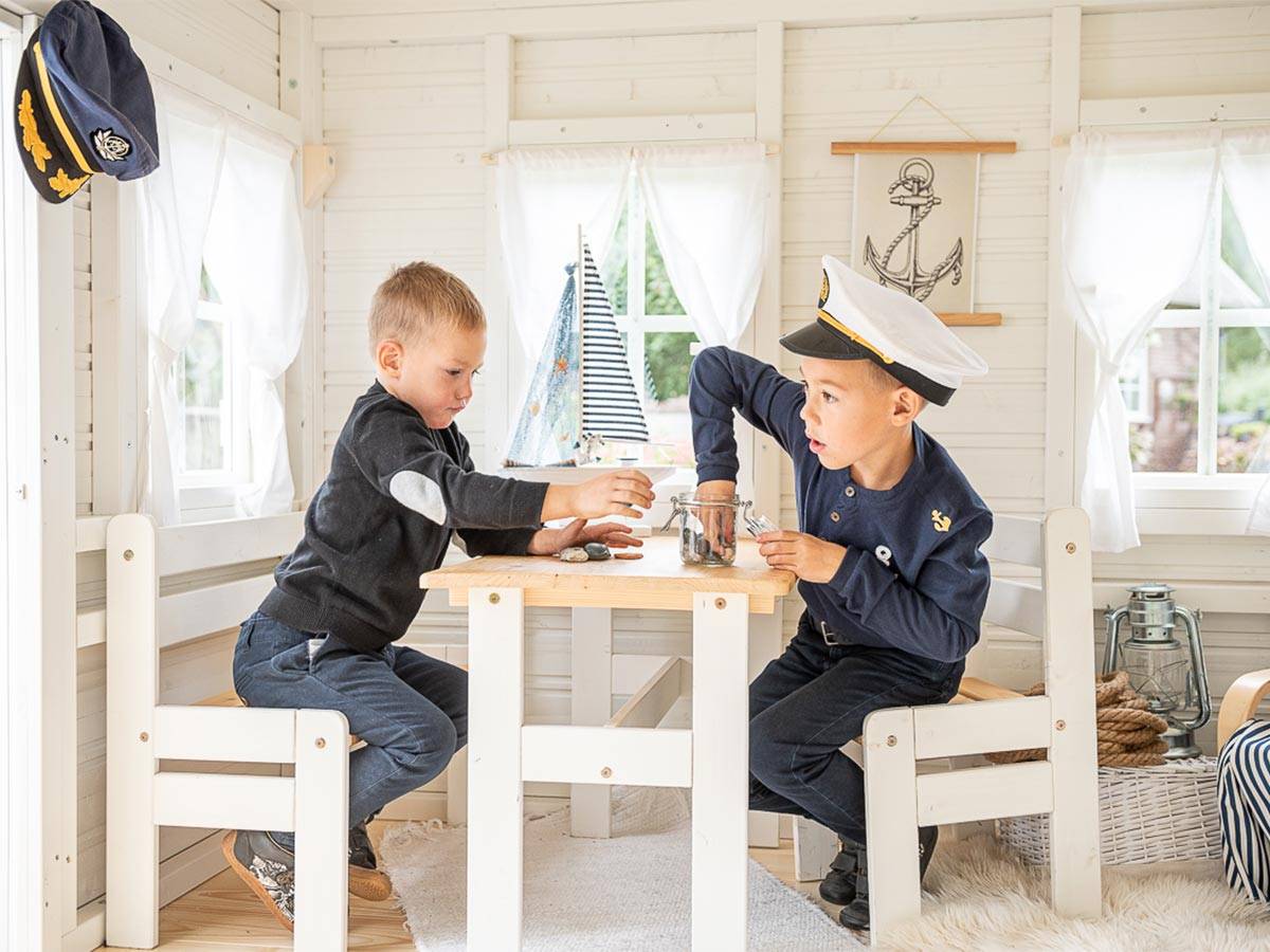 Two boys playing inside of kids playhouse