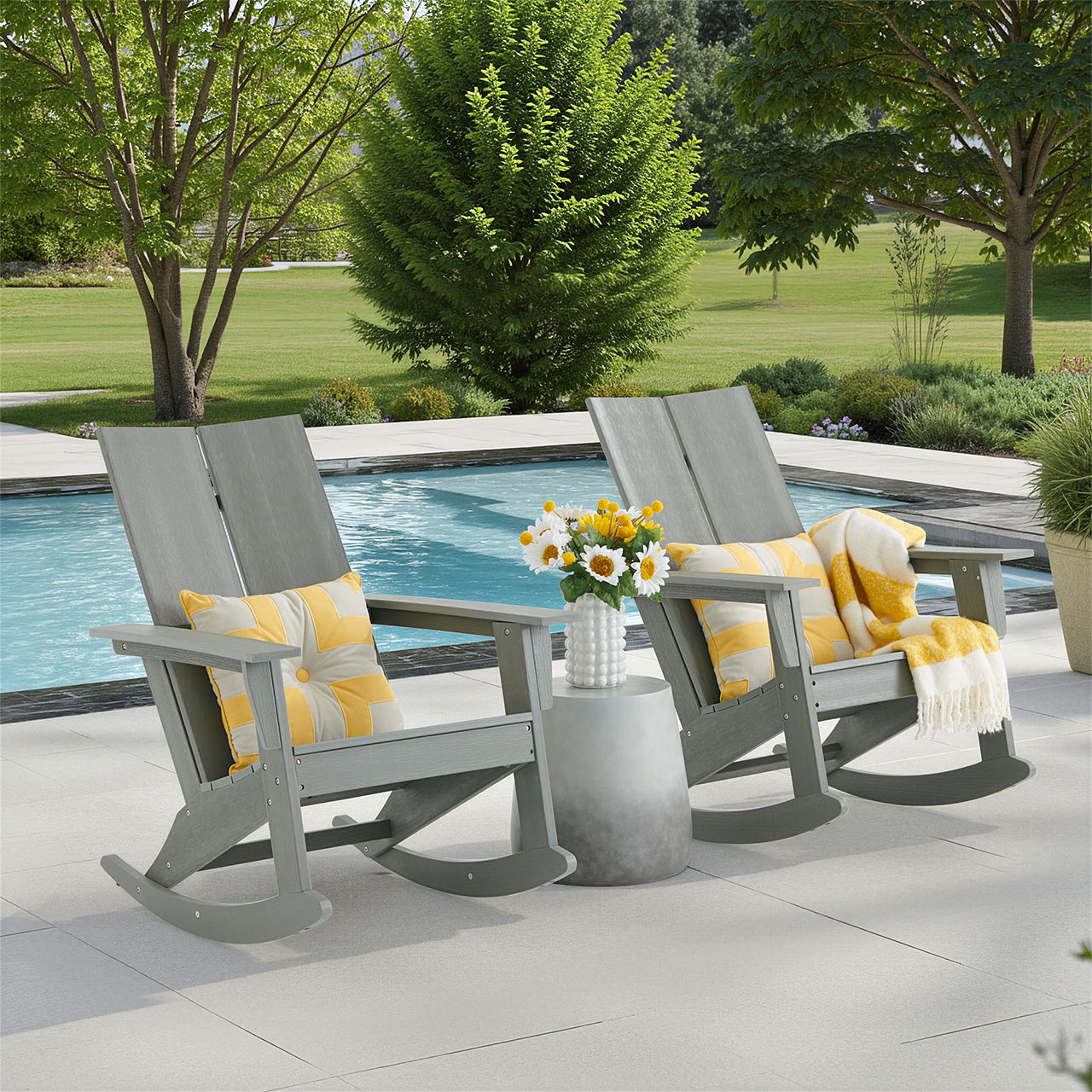 Two gray rocking chairs by a pool with yellow blankets and sunflowers.