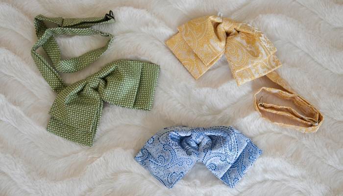 Three womens floppy bow ties laying on a fur blanket