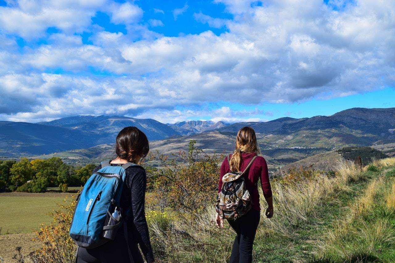 Two Women Walking On A Hill