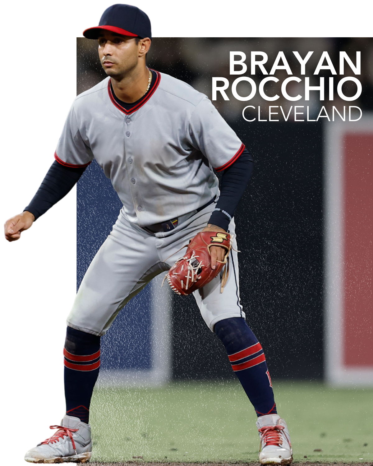 A baseball player in a gray uniform, poised in a fielding position.