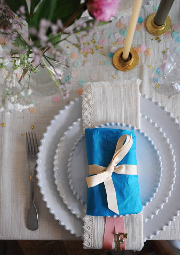 A present wrapped in Rico Design teal blue tissue paper and tied with ecru grosgrain ribbon.