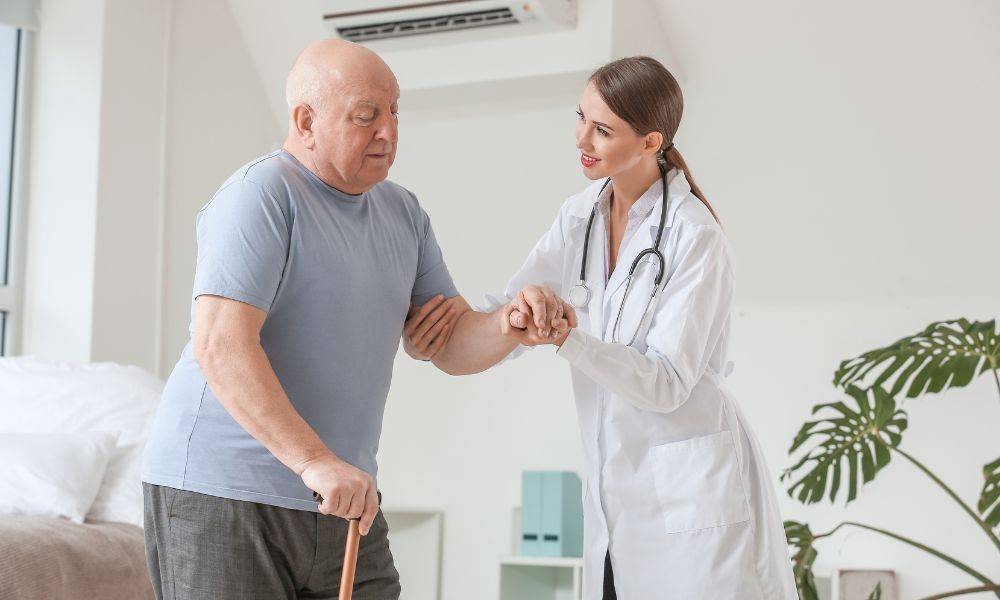 Man getting assistance from doctor in order to stand