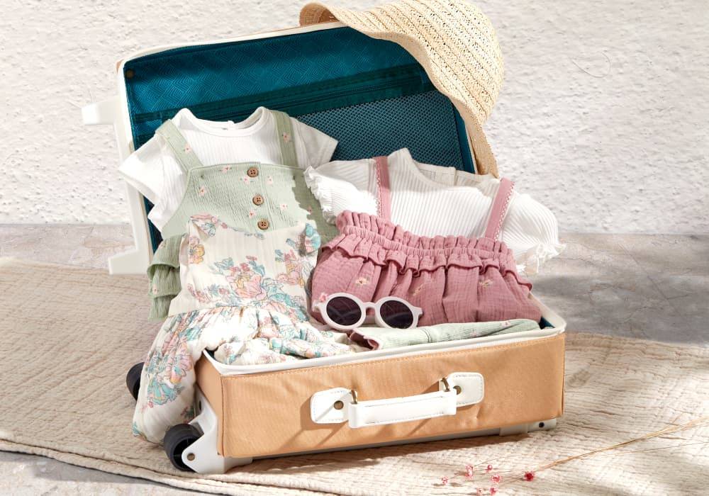 Girls clothing laid in a blue suitcase