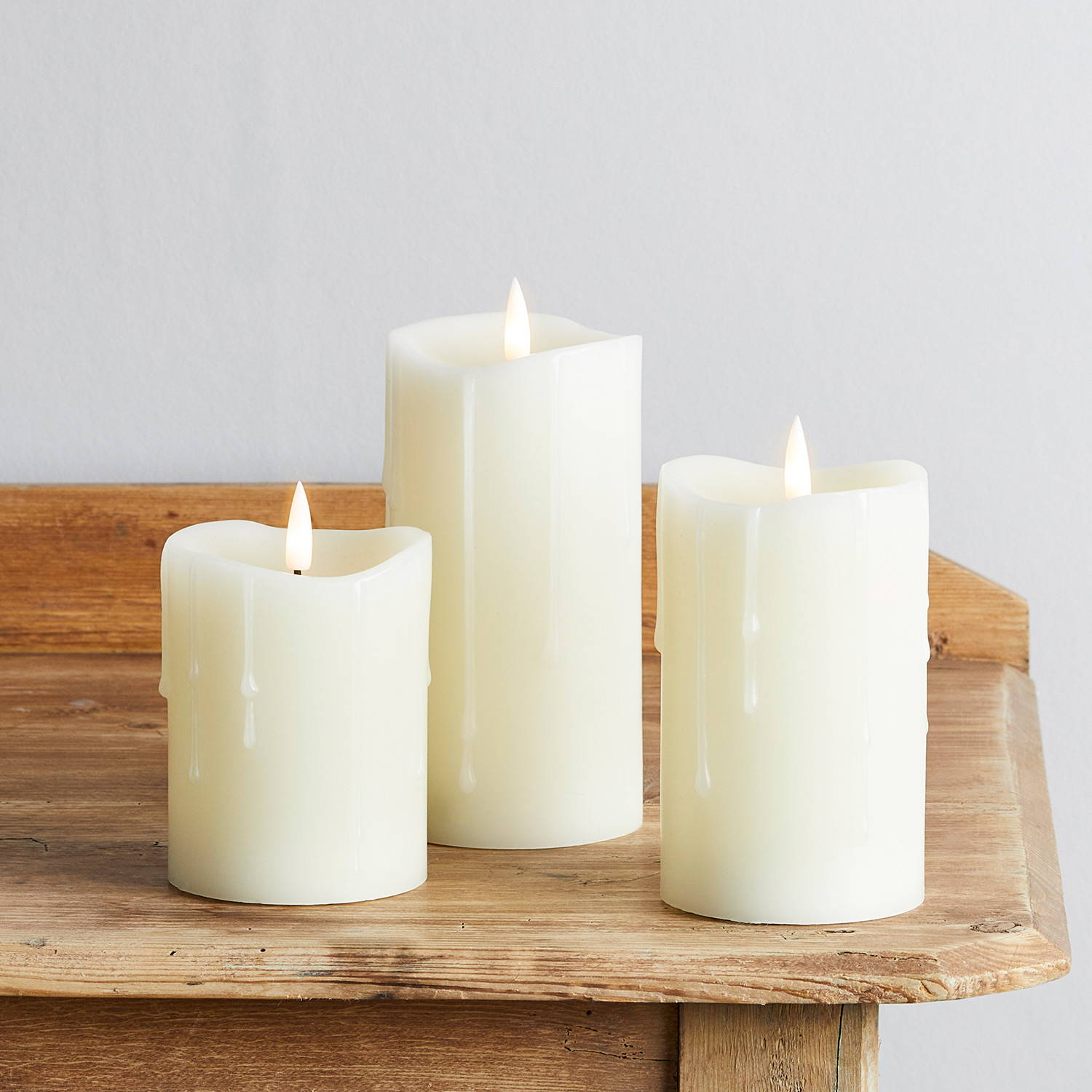 Dripping wax candles illuminated on table