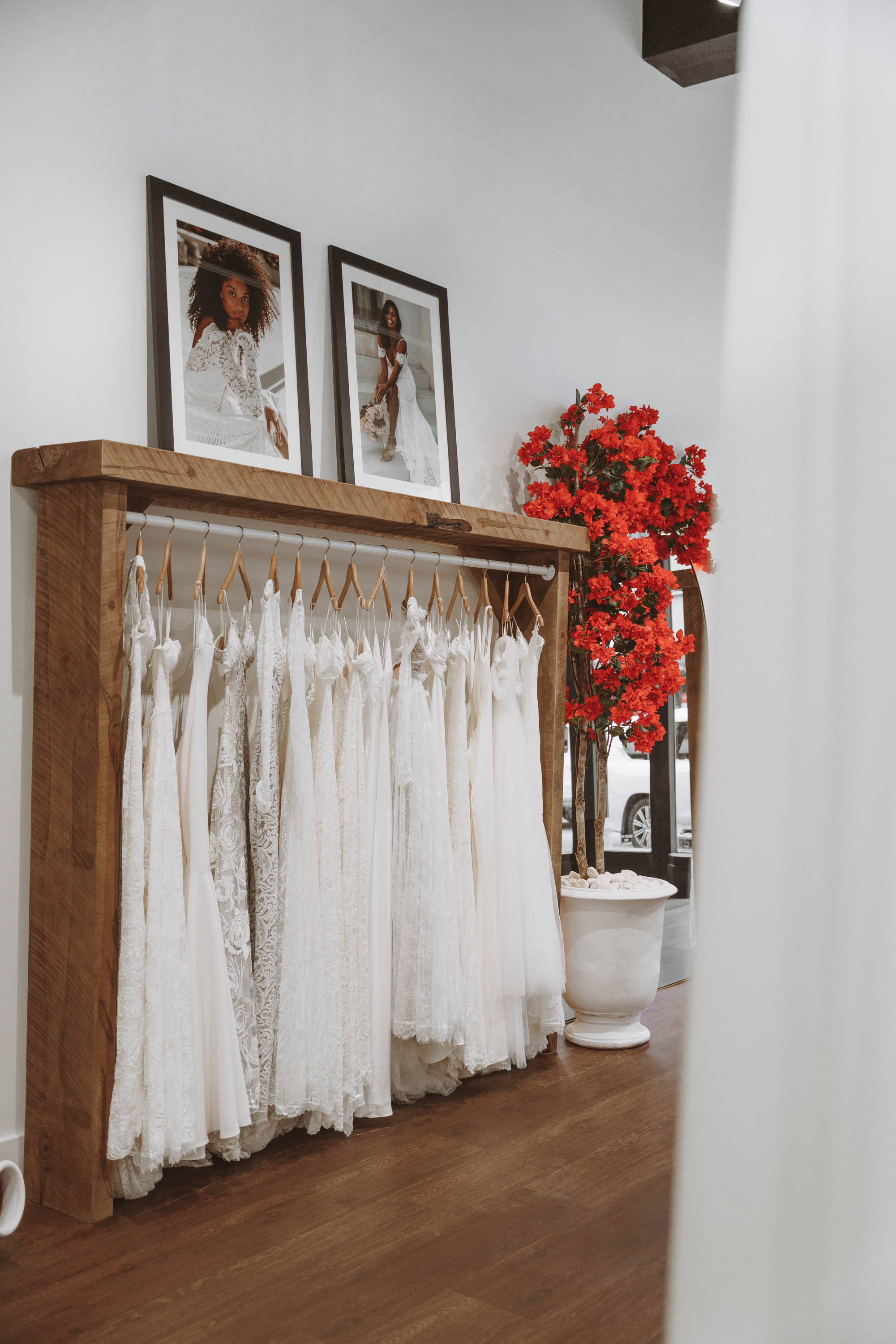 Grace Loves Lace dresses hanging on timber rack with red flowers