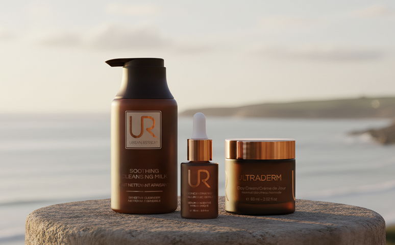 Three URBAN RETREAT skincare products on a stone with a beach background.