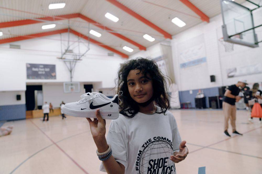 kid posing with a nike shoe