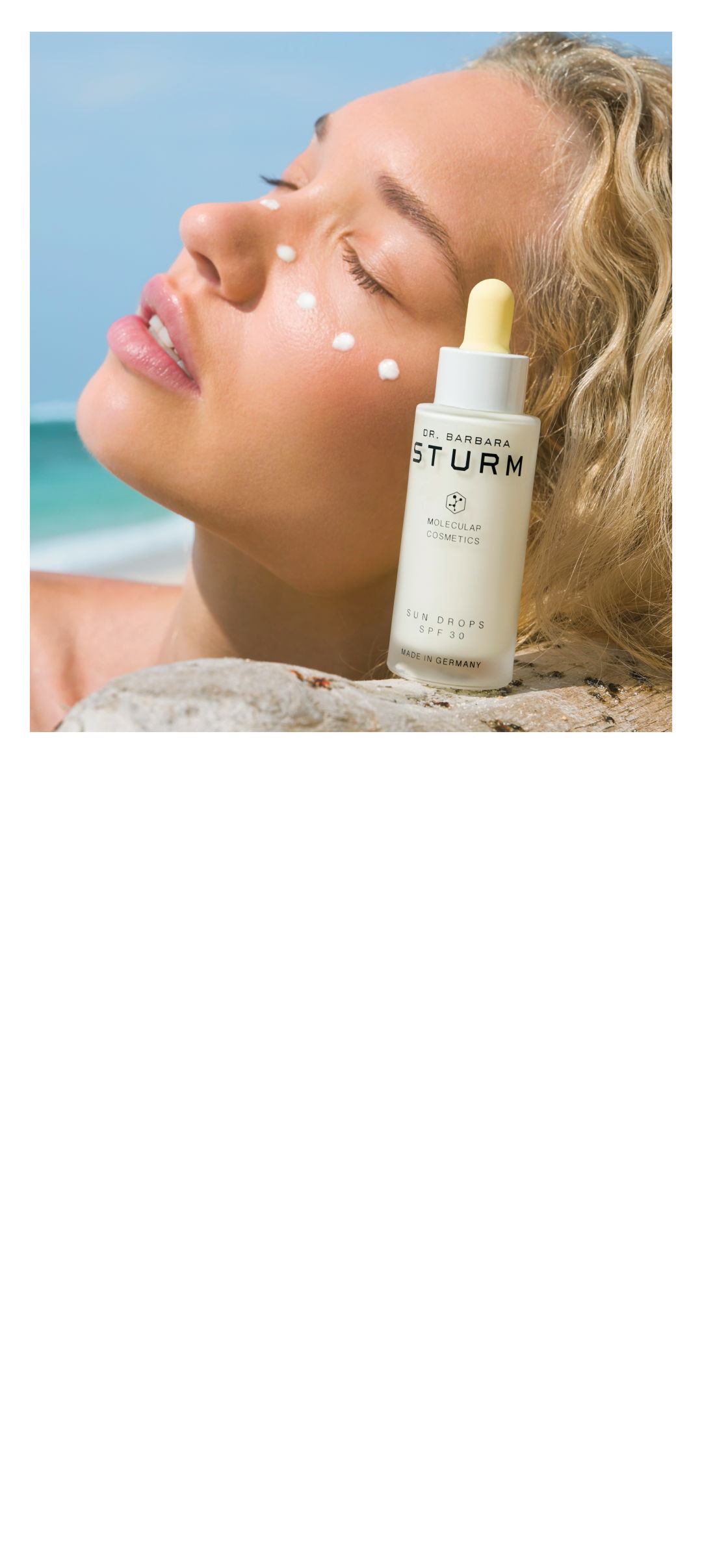 Woman applying skincare product on her face by the beach.