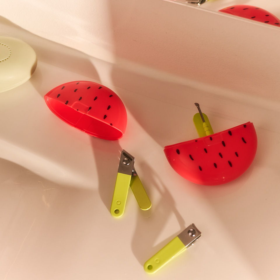 Colorful watermelon-shaped items and yellow tools on a countertop.