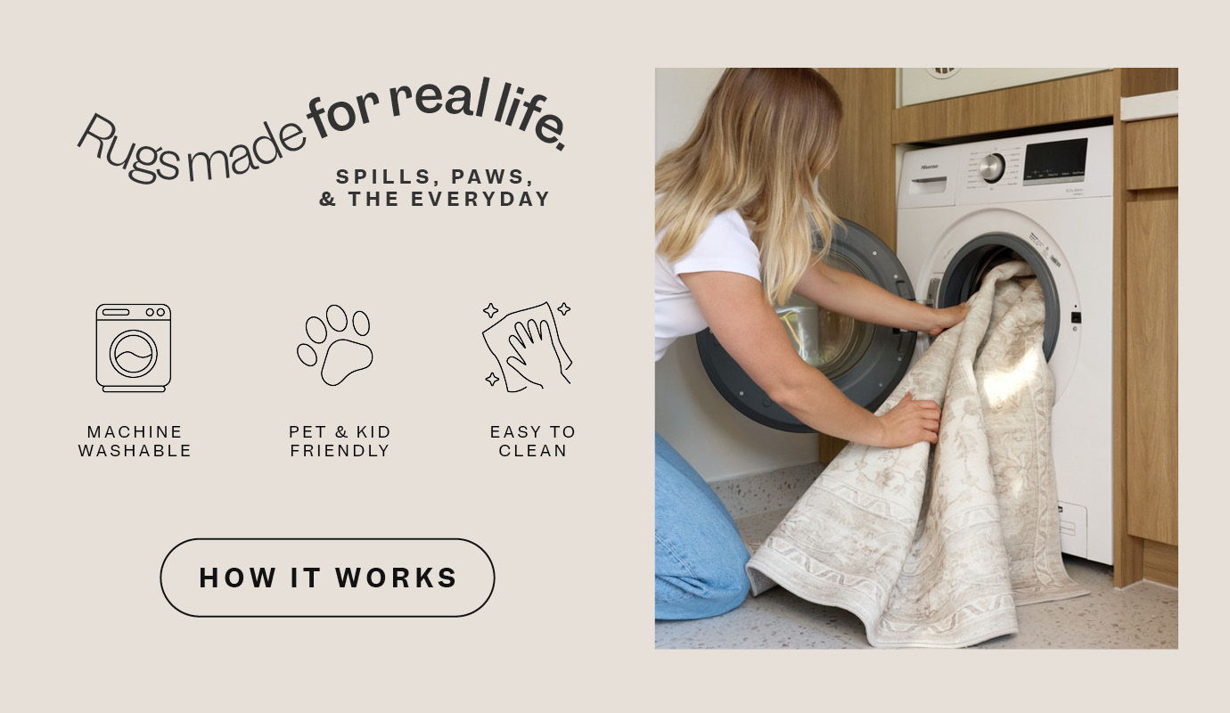 Person loading a washing machine with laundry.