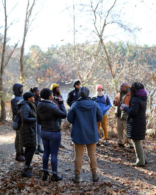 Group of people gathered in circle in woods talking