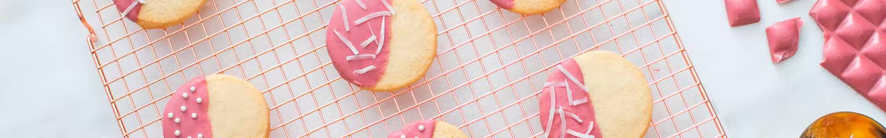 ruby chocolate dipped cookies on drying rack