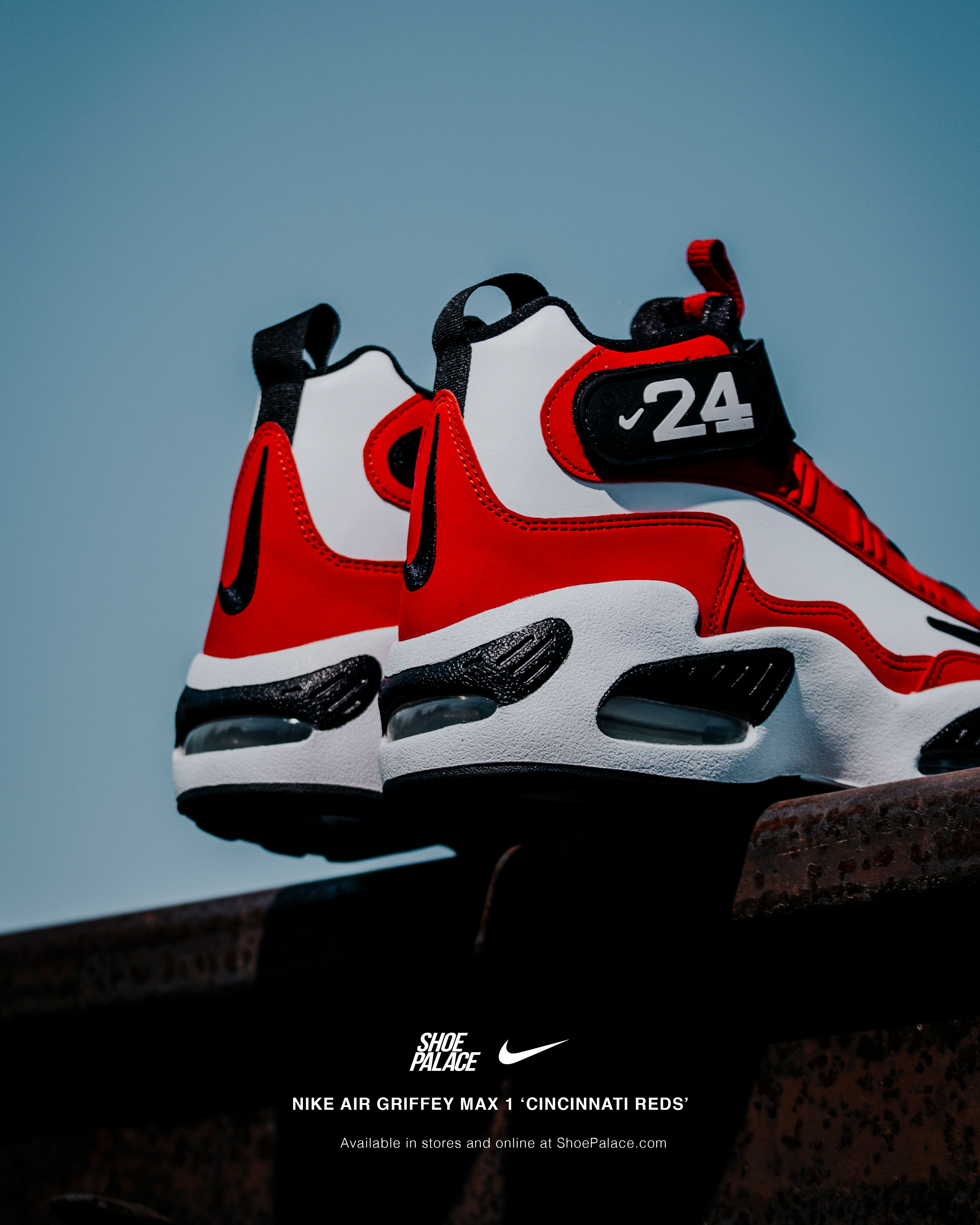 Nike Air Gravity Max 1 sneakers in red and white against a blue background.