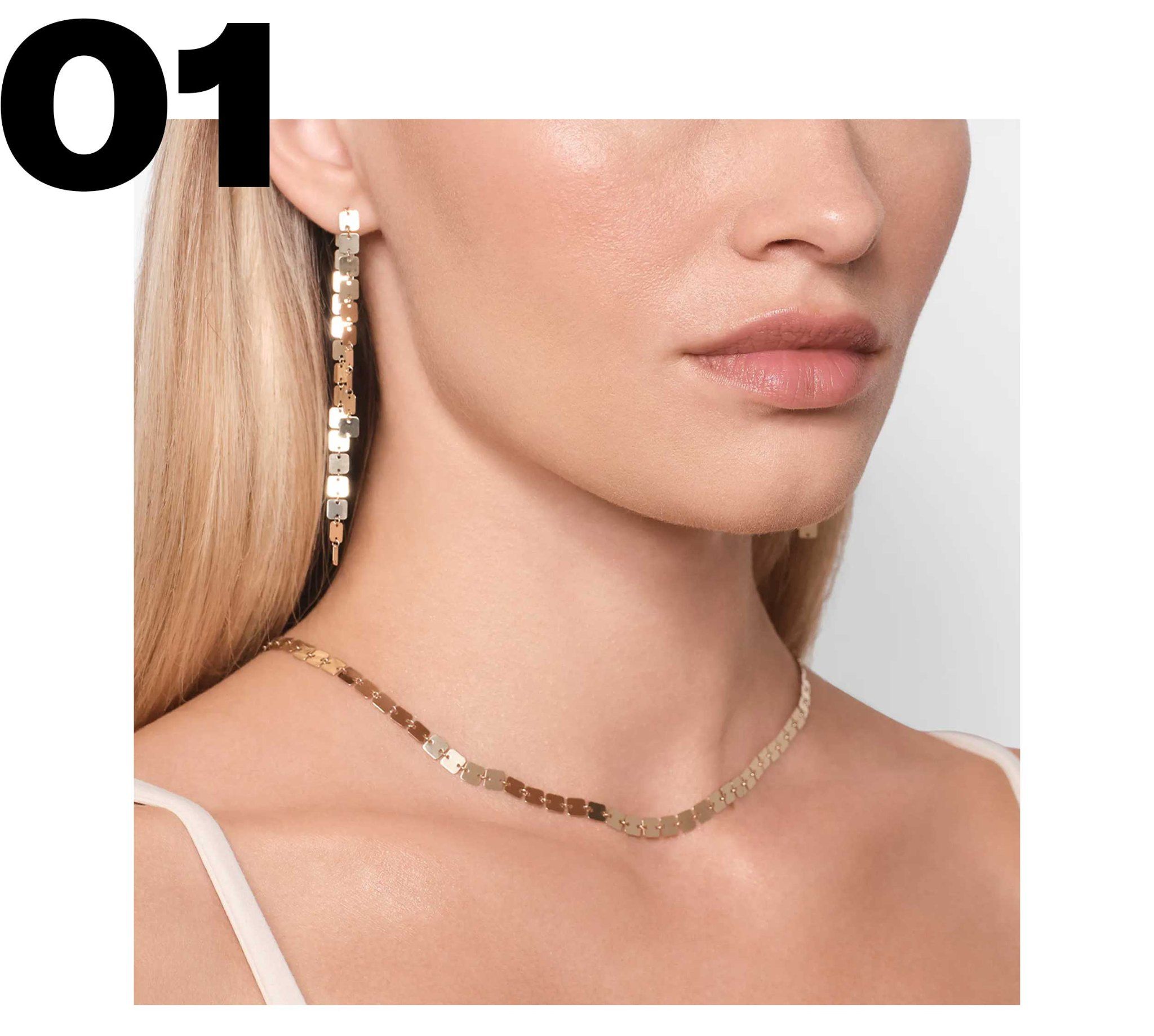 Model wearing a square chain necklace and square chain linear drop earrings.