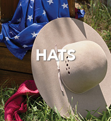 A wide-brimmed hat on grass with a blue and red fabric backdrop.