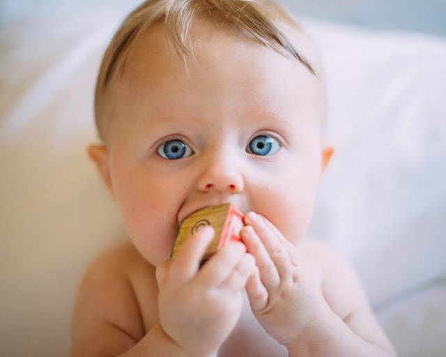 Baby With Block In Mouth