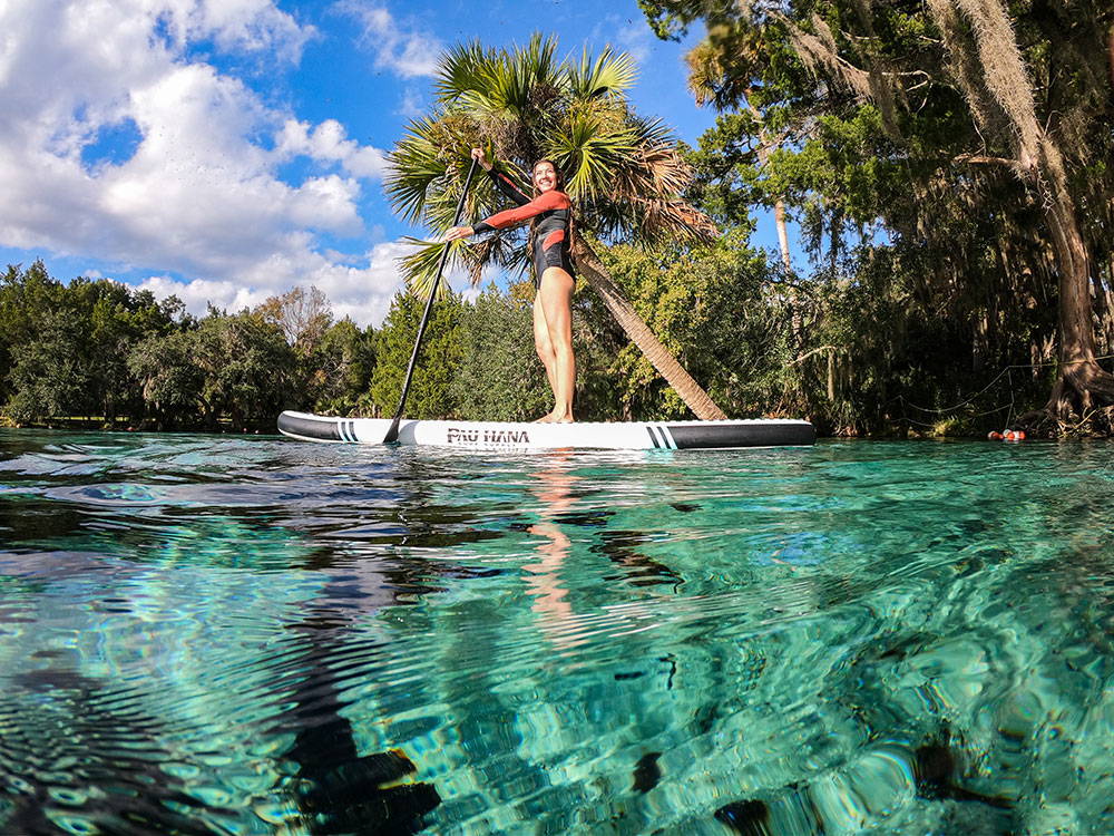 A woman paddling over the crystal clear waters in Florida