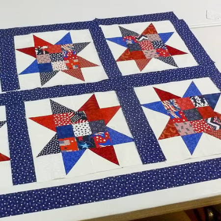 piecing different star shaped quilt blocks with blue sashing strips in between