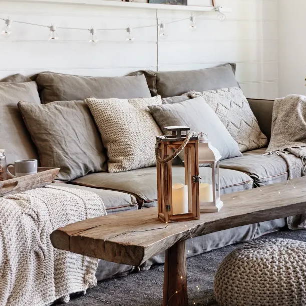 Cosy living room space with an indoor lantern, LED lights and textured sofa accessories